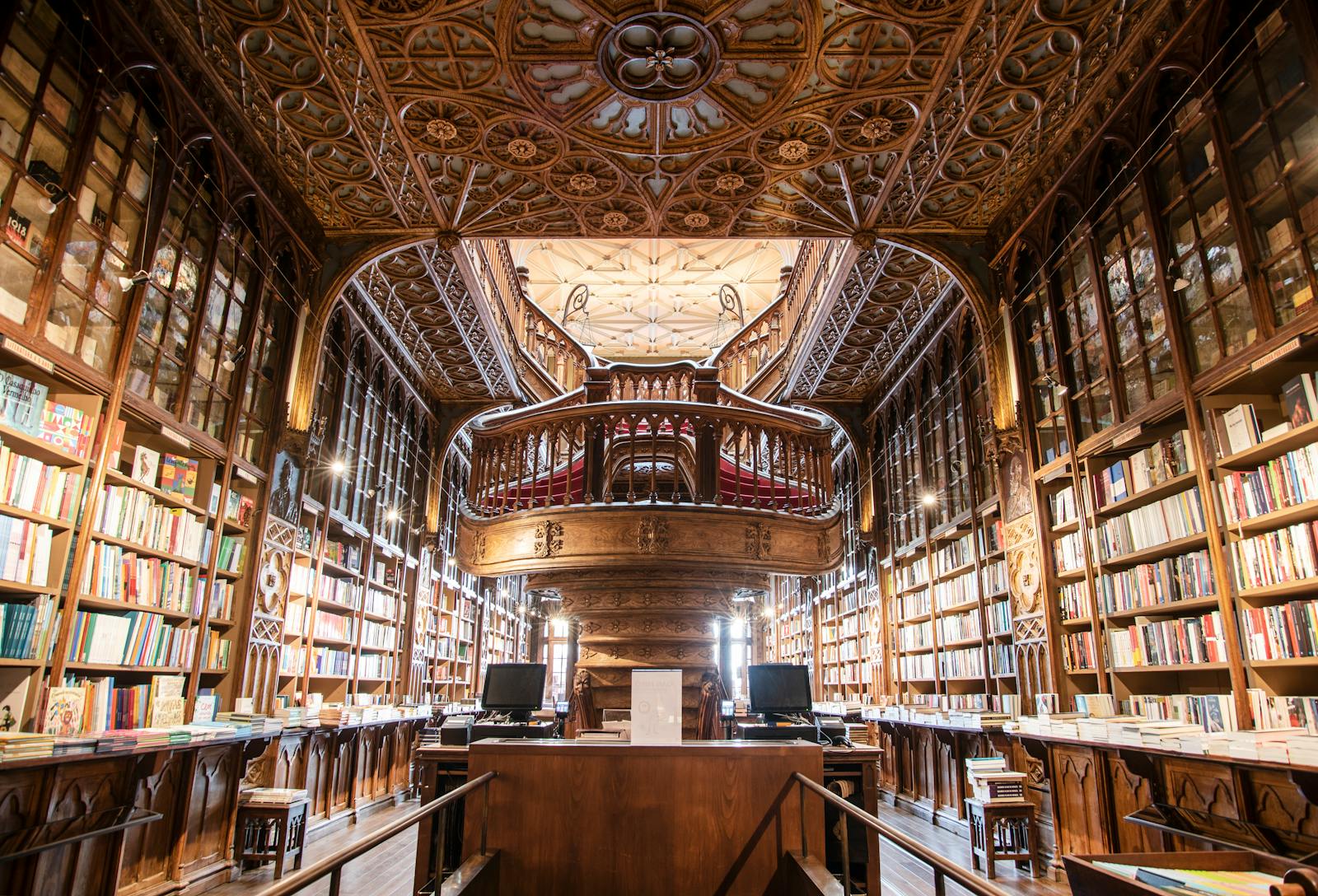 Corner view of a library with dark wooden bookshelves filled with a variety of books.